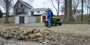 Person standing in front of a house and out buildings.