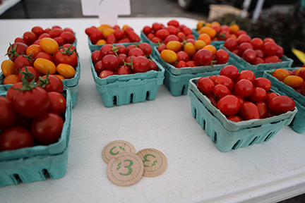 Cartons of tomatoes at a farmers market.