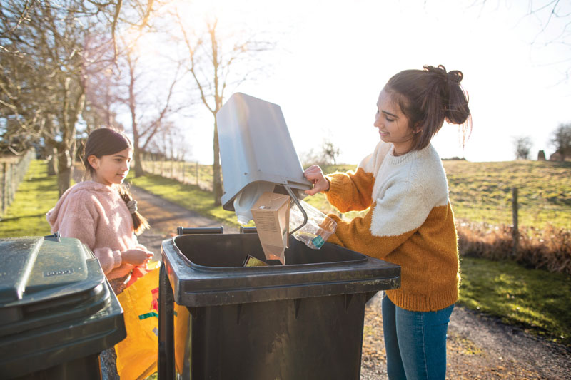 A photo of two children recycling
