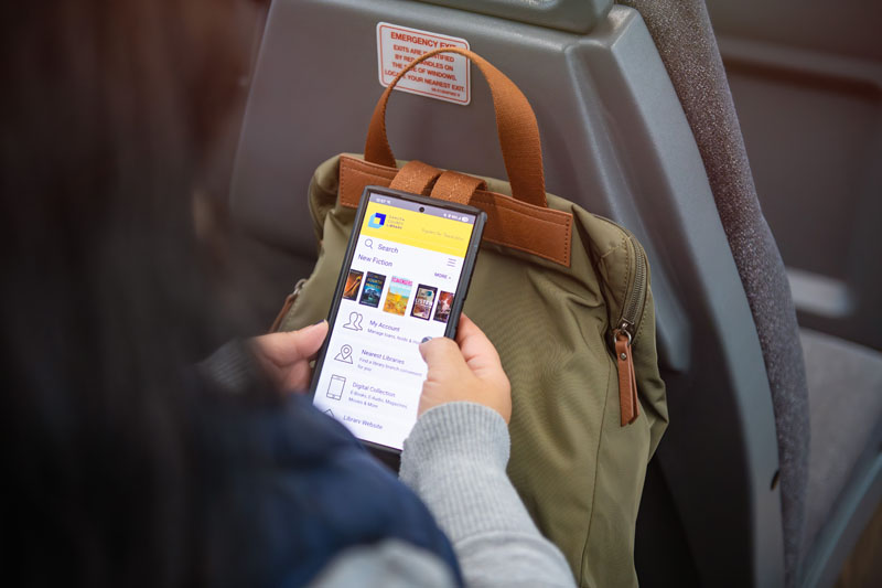 Closeup of woman holding a phone with the library app.
