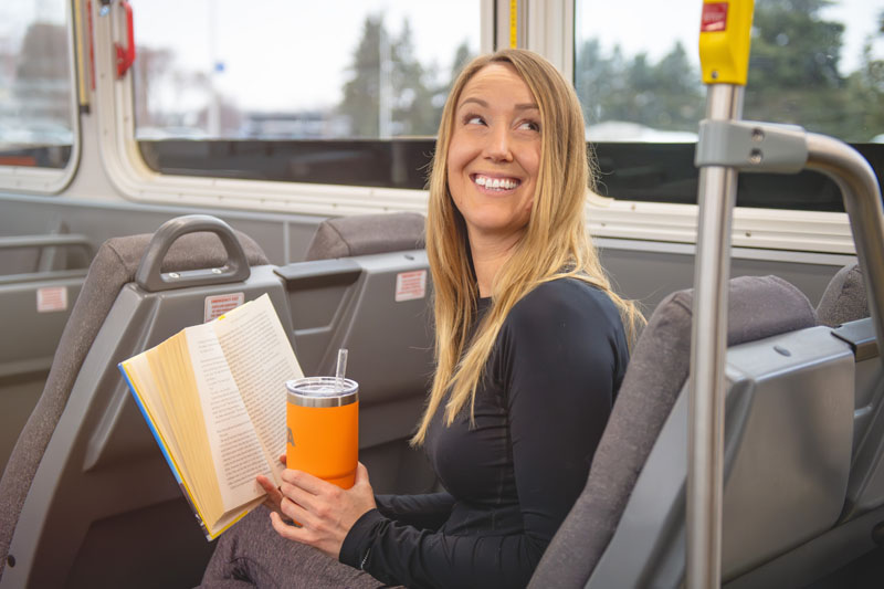 Woman reading a book on the bus.