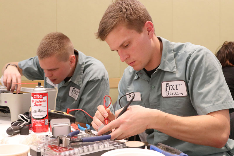 Two men fixing a printer at a Fix-It Clinic.