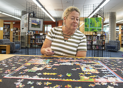 Adult woman putting a puzzle together.