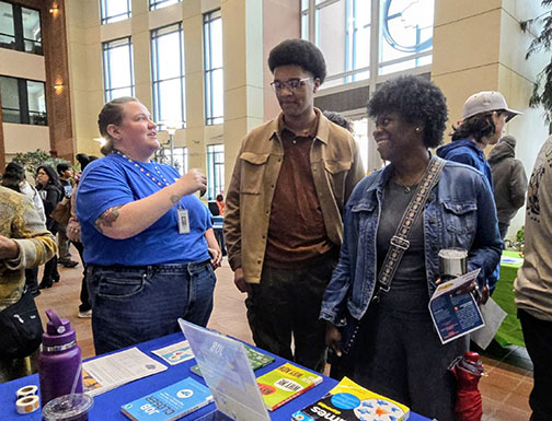 A parent and teen speaking with a representative at the Teen Job Fair.