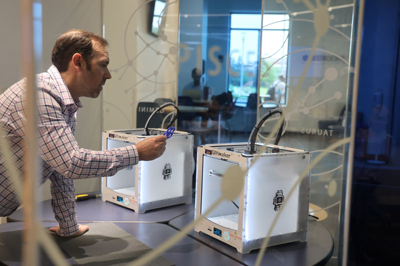 Person using 3D printer in iLAB.