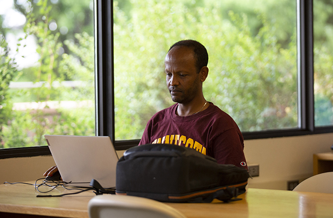 Adult using laptop at library.