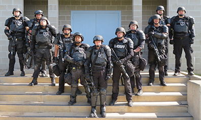 SWAT team members standing in a V formation on a set of stairs.