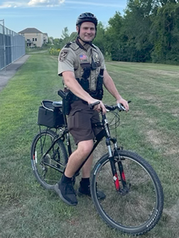 Bike patrol deputy on a bicycle in the summer.