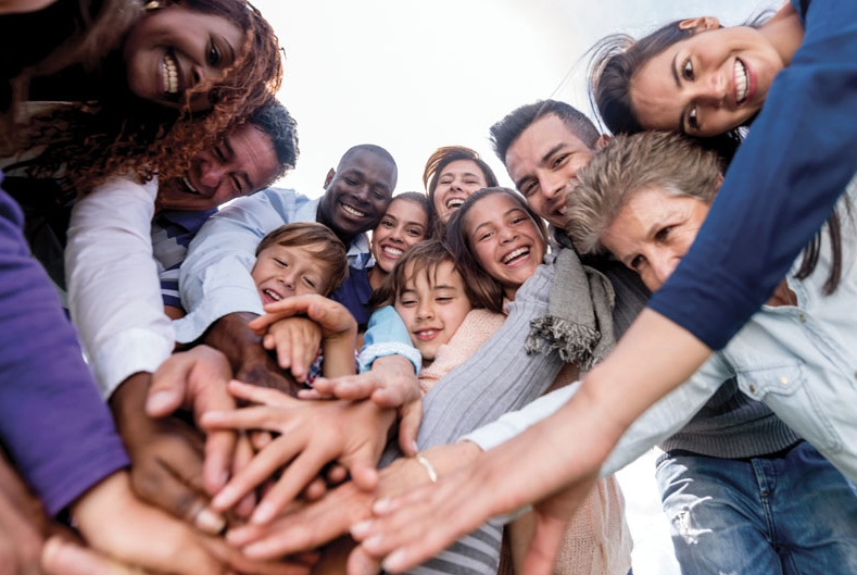 Happy people with hands stacked together