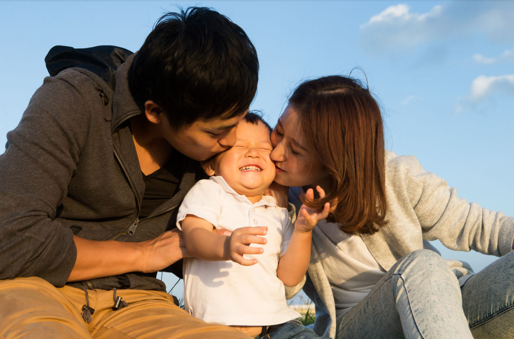 Two parents with a child smiling.