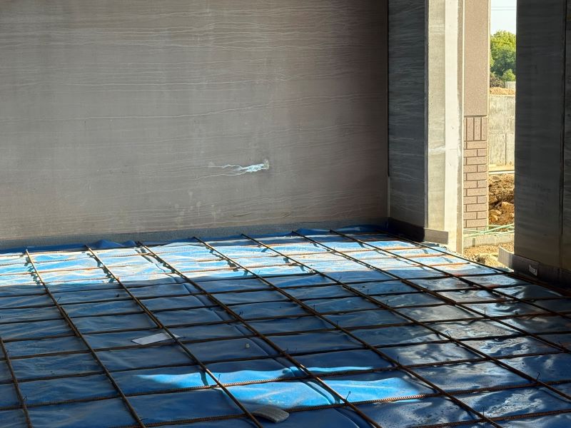 A photo of a floor with blue tarp and iron webbing