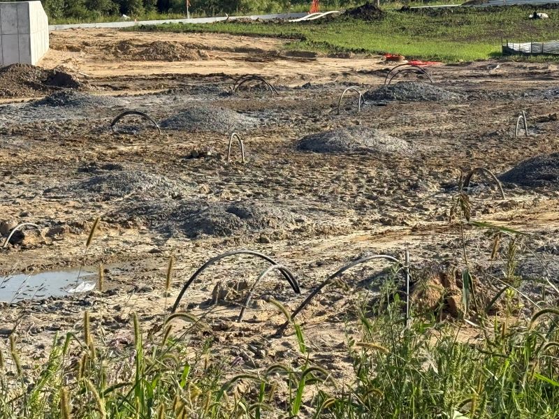 A photo of geothermal well arches woven into the dirt ground