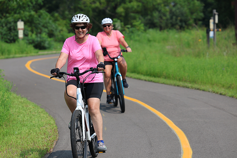 Two women biking on Mississippi River Greenway.