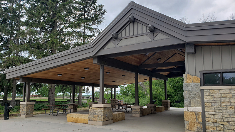 A picnic shelter with trees behind it.