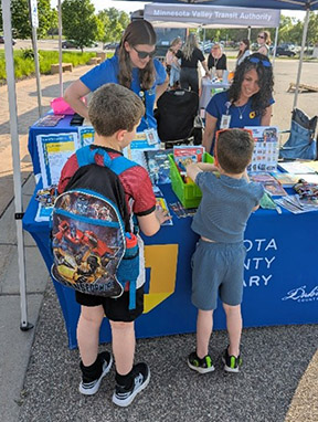 Two kids at a Dakota County Library event table. 