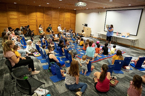 A large group of kids and parents at a library storytime. 