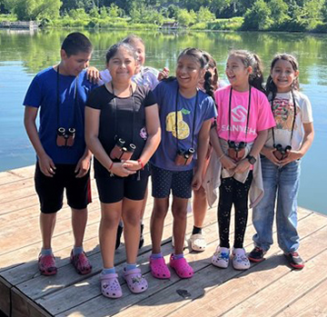 Group of summer campers posing on a dock.